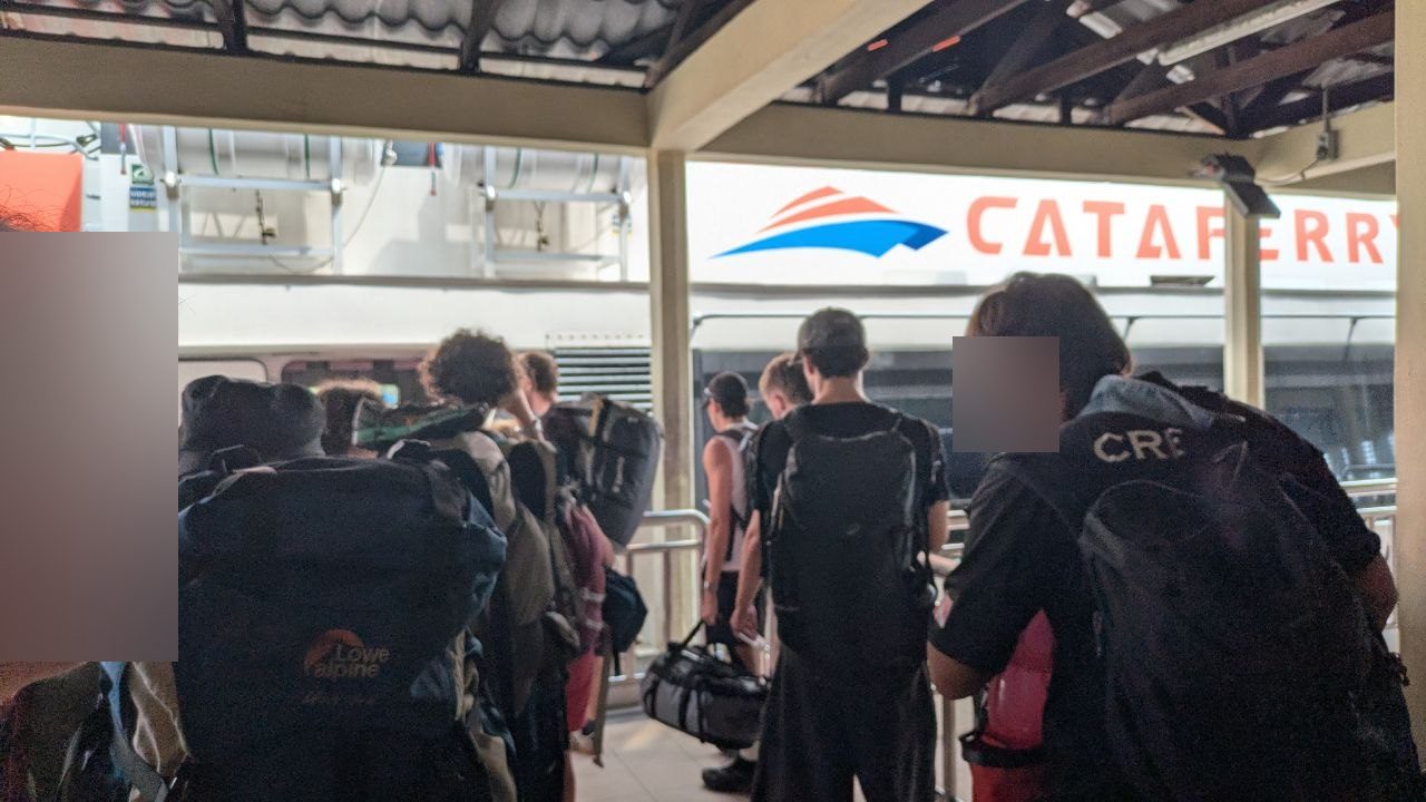 The boarding queue on the pontoon in Mersing, with the Cataferry catamaran alongside.